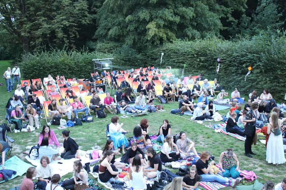 Besucher*innen des Sommerkinos warten gespannt auf die Filmvorführung.